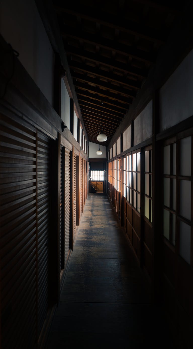 A serene view of a traditional Japanese corridor with wooden elements in a Kyoto ryokan.