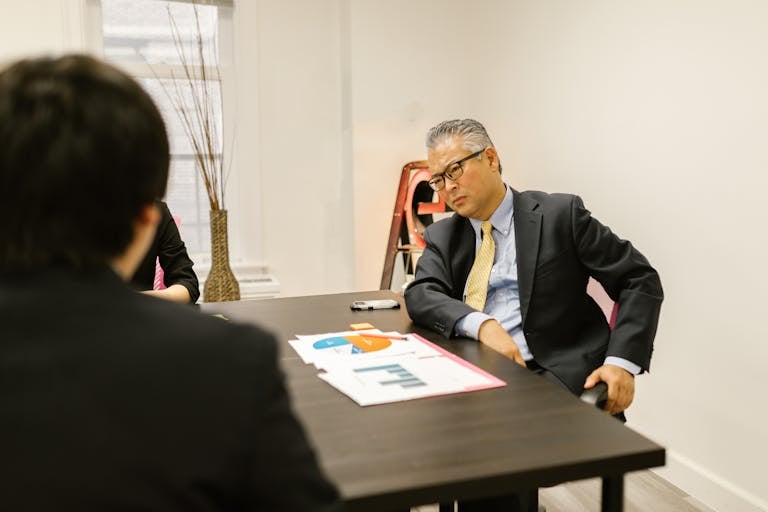 Two professionals discussing charts during a business meeting in an office.